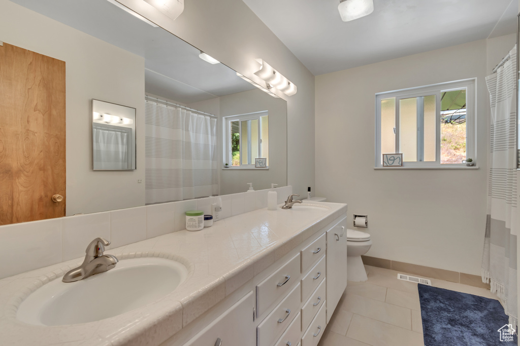 Bathroom with double vanity and tile patterned flooring