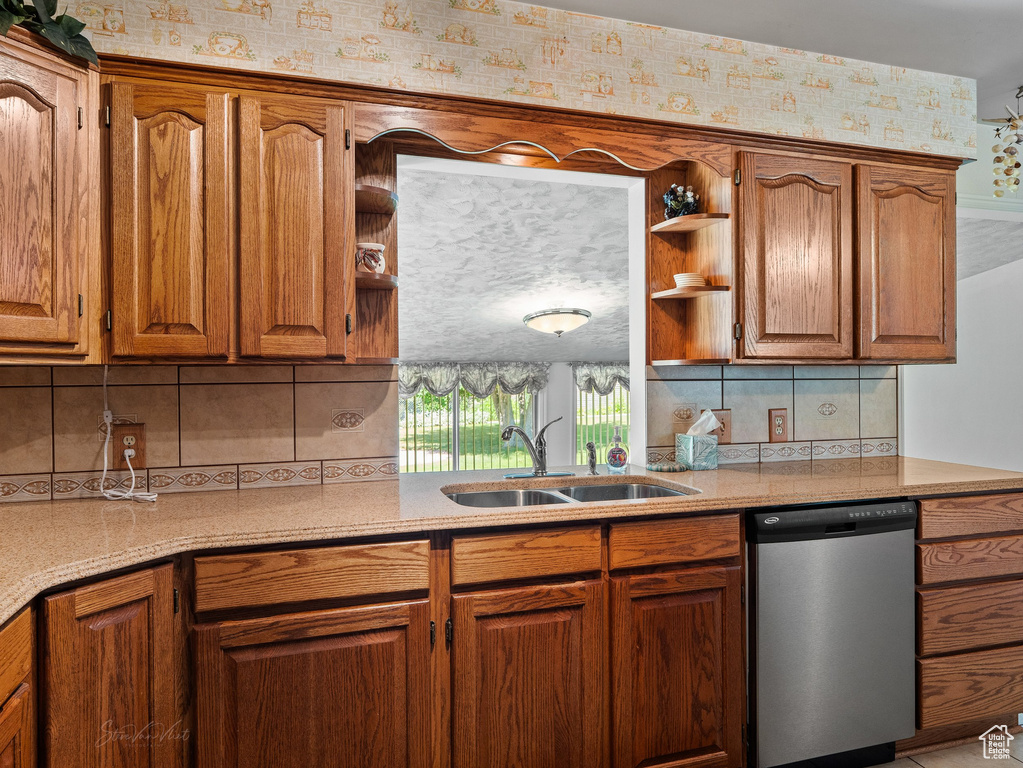 Kitchen featuring stainless steel dishwasher, open shelves, and brown cabinetry