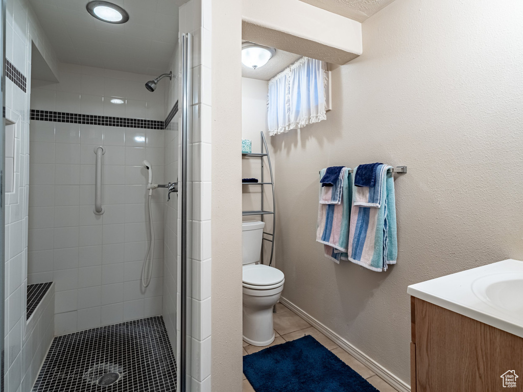 Bathroom featuring a shower stall, vanity, and tile patterned flooring