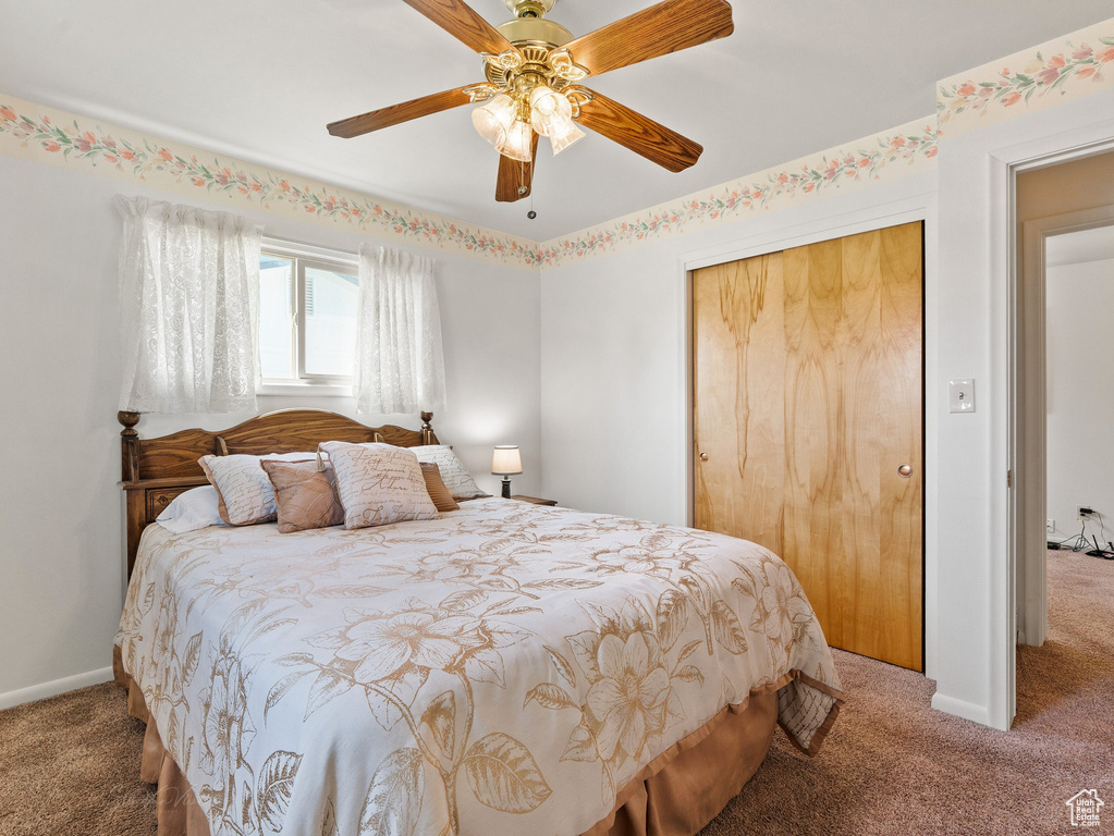 Carpeted bedroom featuring a closet and a ceiling fan