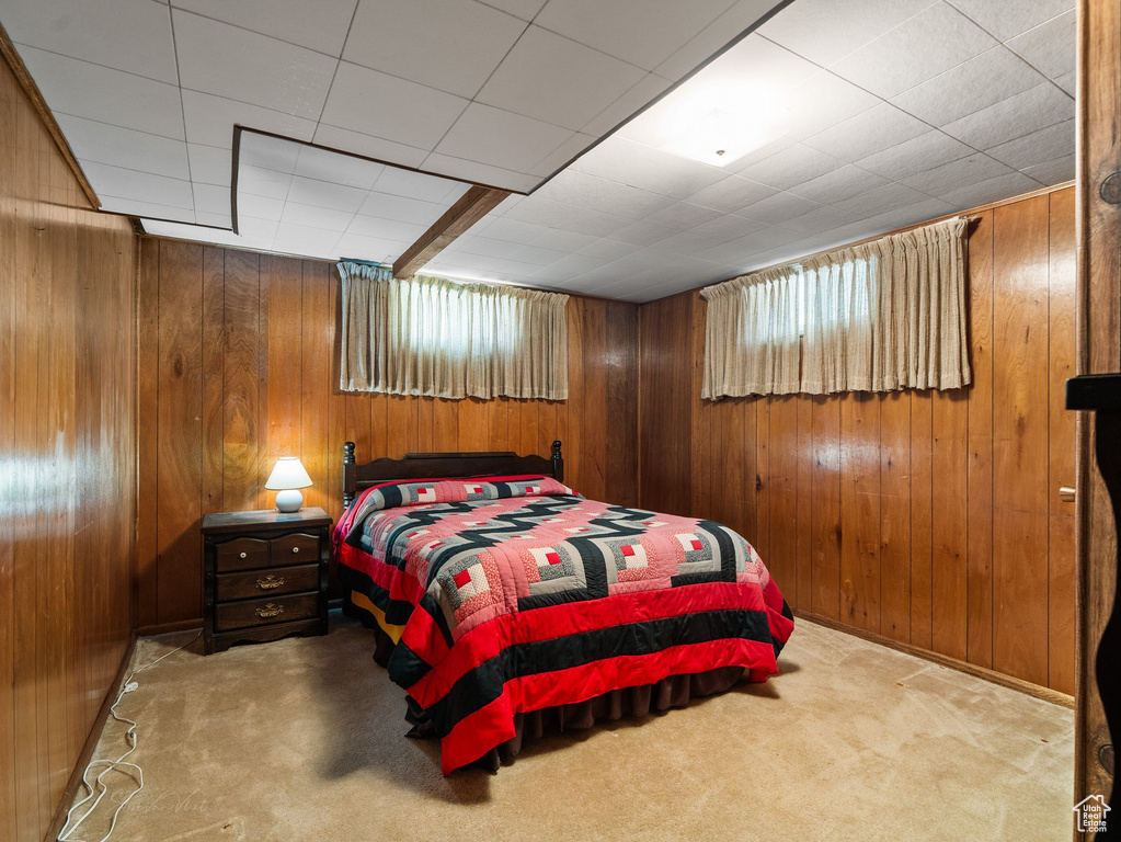 Bedroom featuring carpet floors and wood walls