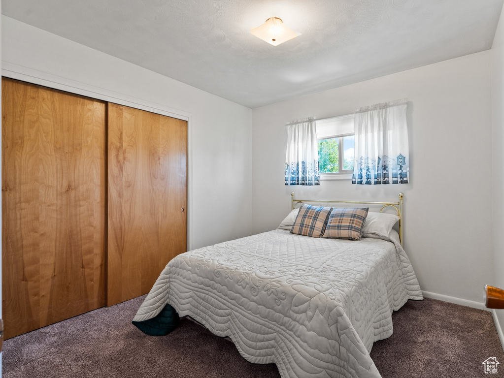 Carpeted bedroom featuring a closet and baseboards