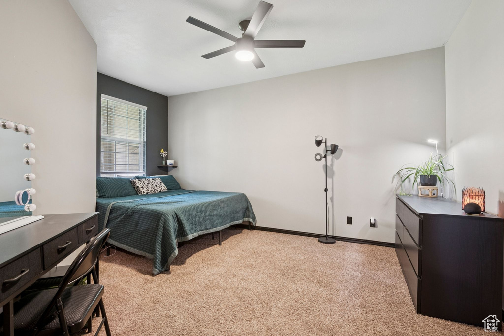 Bedroom with light colored carpet and a ceiling fan