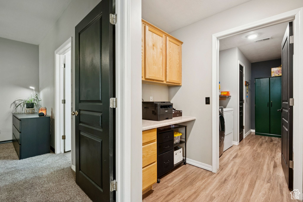 Kitchen featuring light brown cabinetry, separate washer and dryer, light countertops, and light wood-type flooring
