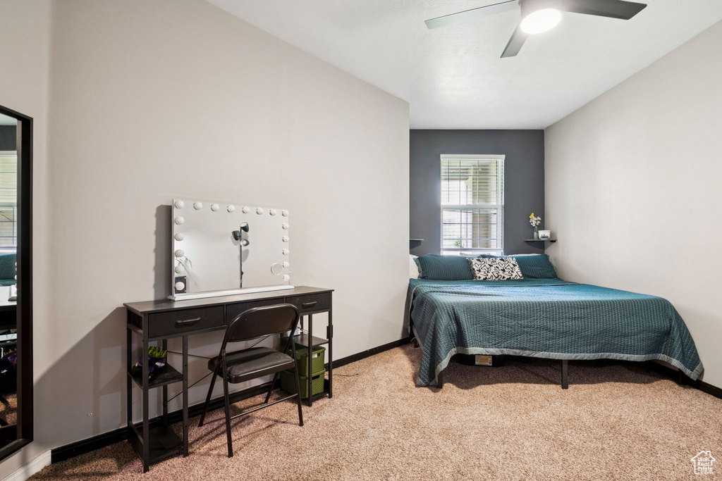 Carpeted bedroom featuring baseboards and ceiling fan