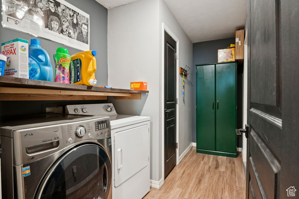 Laundry area with light wood-style flooring and washer and dryer
