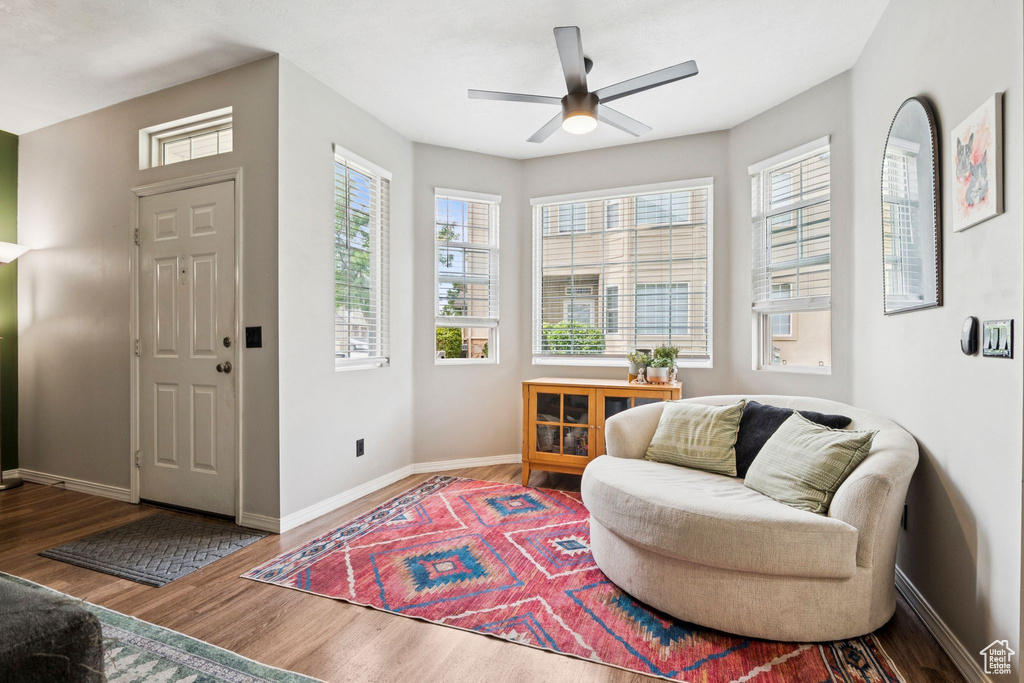Sitting room with healthy amount of natural light, wood finished floors, and ceiling fan