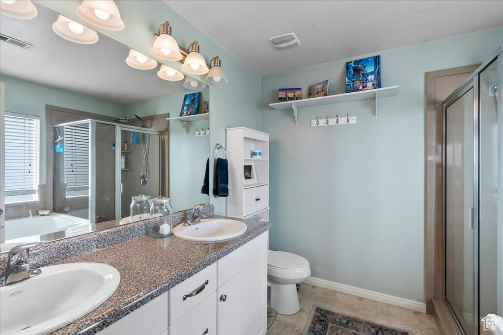 Bathroom with a stall shower, double vanity, and a garden tub