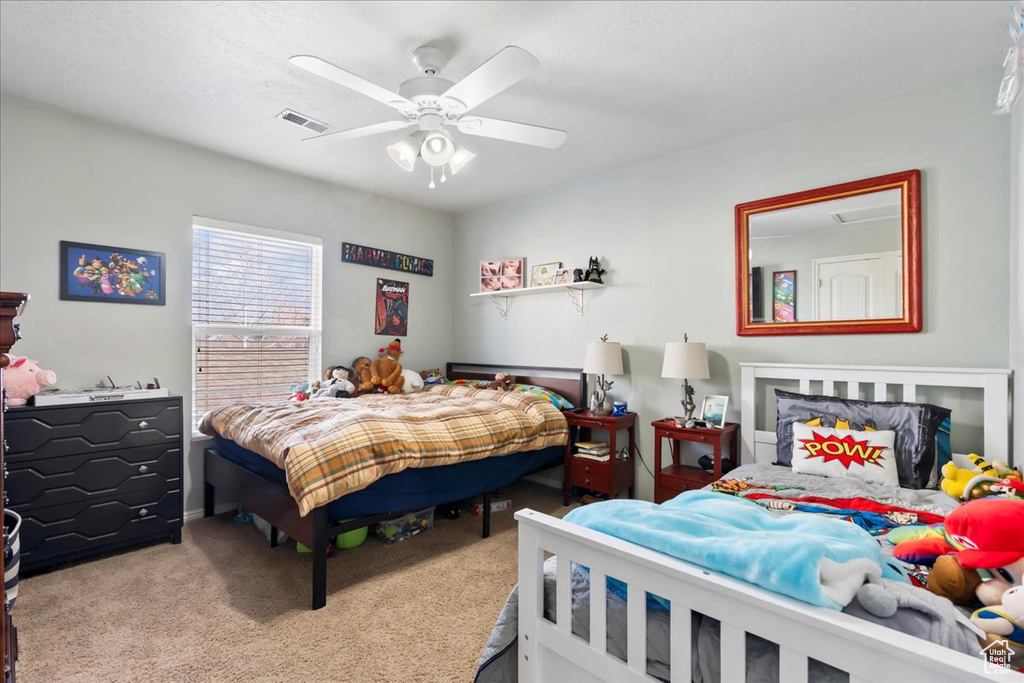 Carpeted bedroom with a ceiling fan