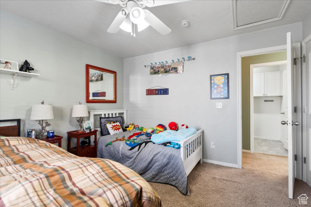 Bedroom featuring carpet flooring, attic access, and a ceiling fan