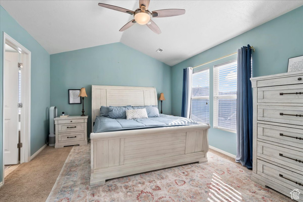 Bedroom with vaulted ceiling, ceiling fan, and light colored carpet