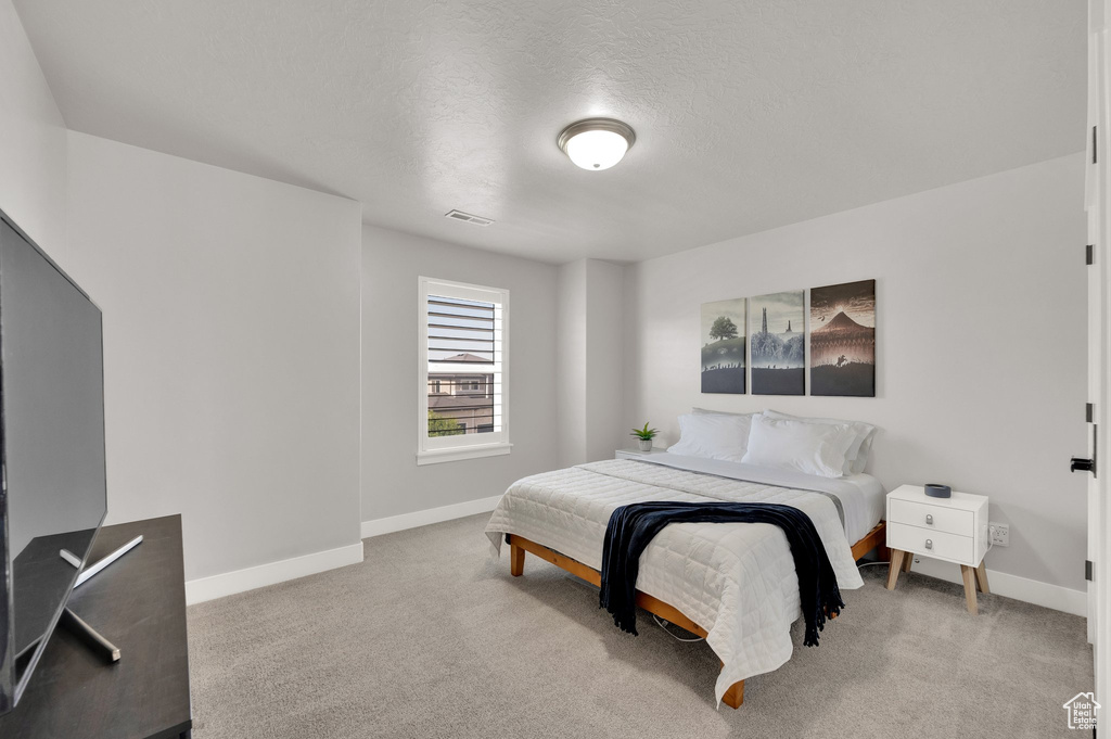 Bedroom with carpet and a textured ceiling