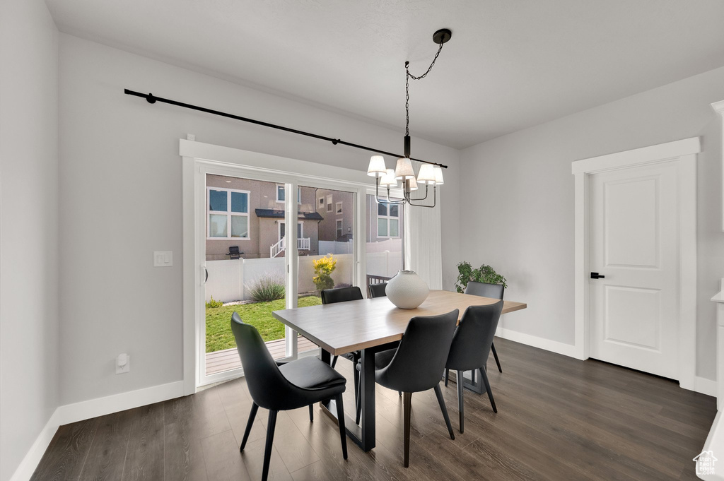 Dining area featuring a chandelier and dark wood-style flooring
