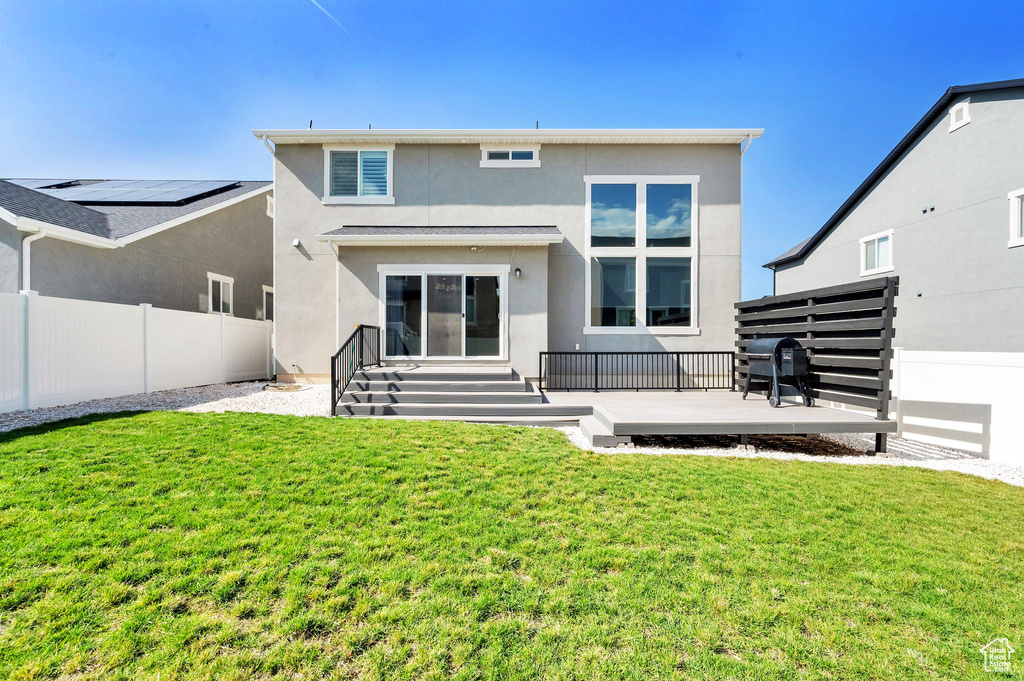 Rear view of house with stucco siding and a deck