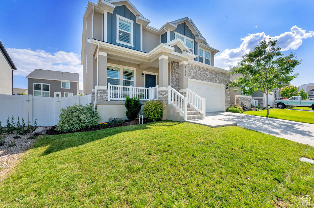 Craftsman inspired home with stone siding, a porch, driveway, and an attached garage