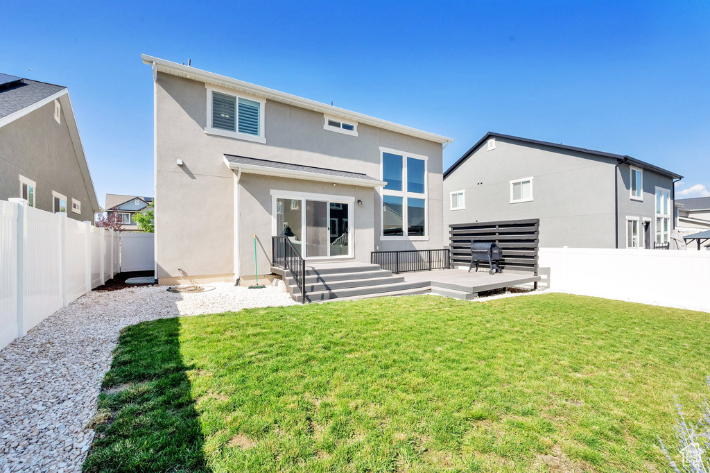 Back of house with a fenced backyard, stucco siding, and a wooden deck
