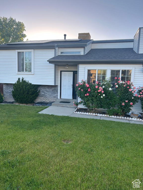 View of front of home with a lawn and a chimney