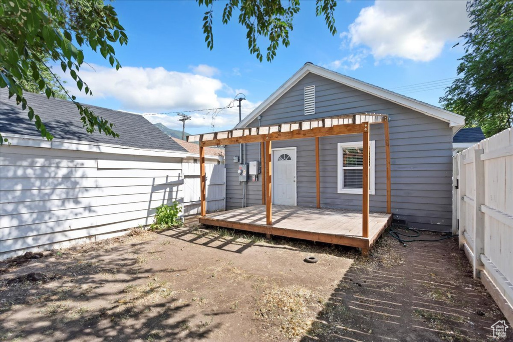 Back of house with a fenced backyard and a wooden deck