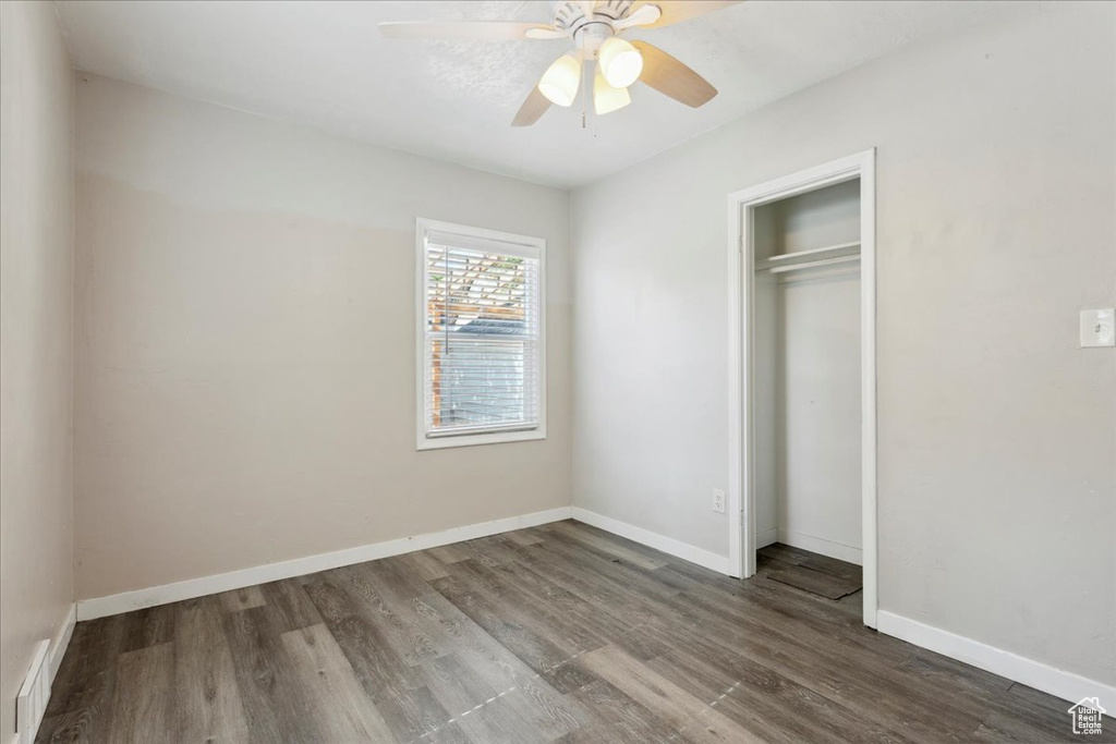 Unfurnished bedroom featuring wood finished floors, a closet, and ceiling fan