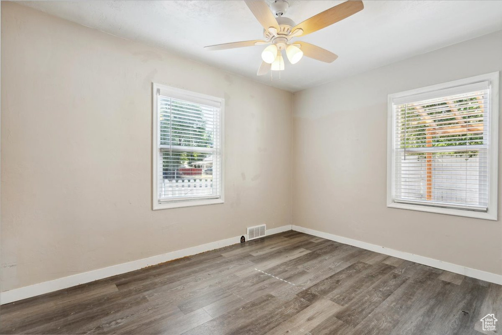 Unfurnished room with wood finished floors and a ceiling fan