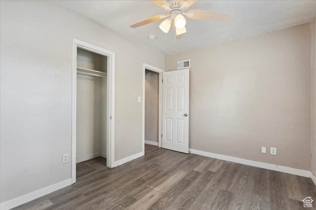 Unfurnished bedroom featuring wood finished floors, a closet, and a ceiling fan