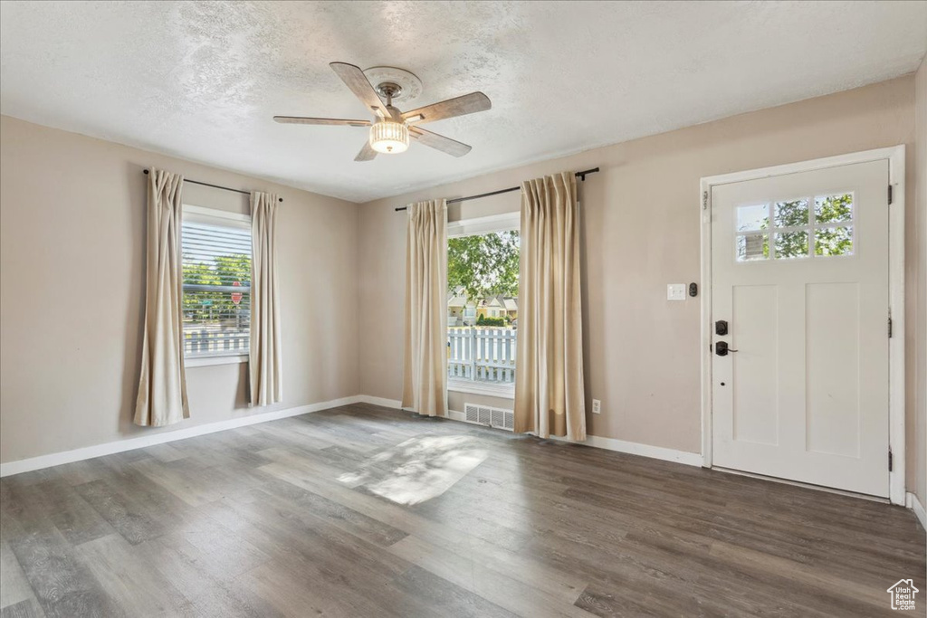 Foyer entrance with a ceiling fan, wood finished floors, and a textured ceiling