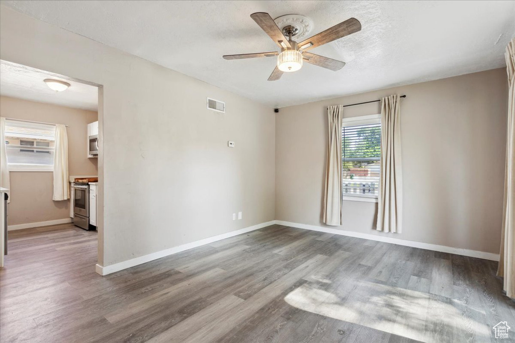 Empty room featuring a ceiling fan and wood finished floors
