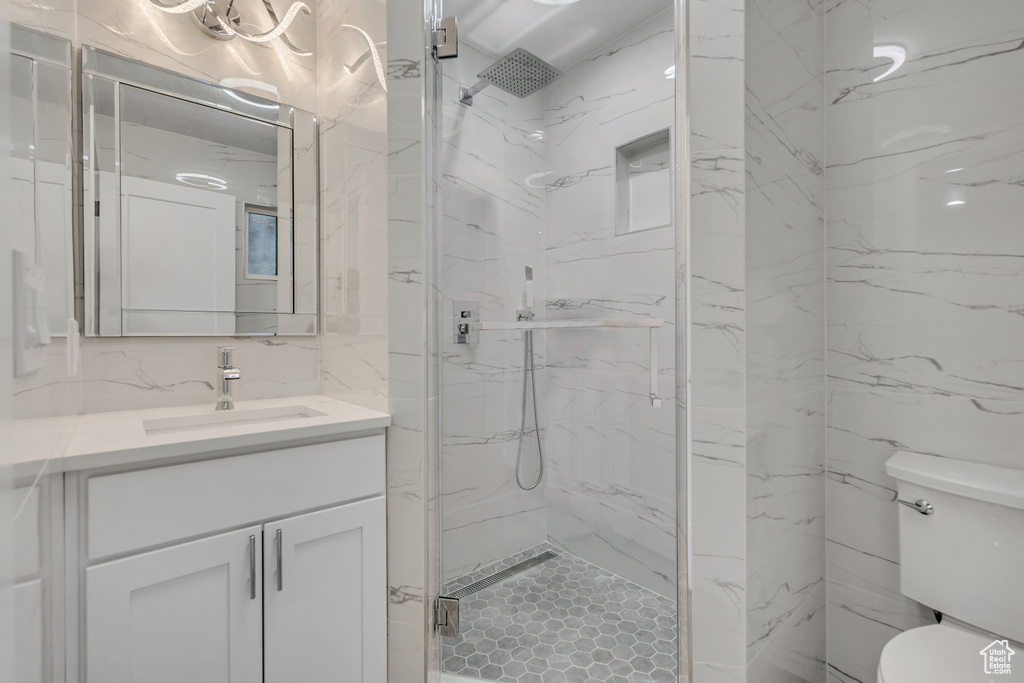 Bathroom featuring vanity and a marble finish shower