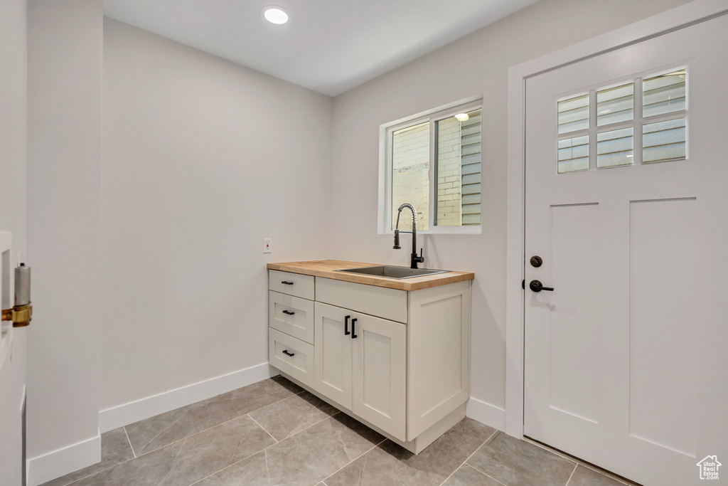 Laundry room featuring light tile patterned floors and recessed lighting
