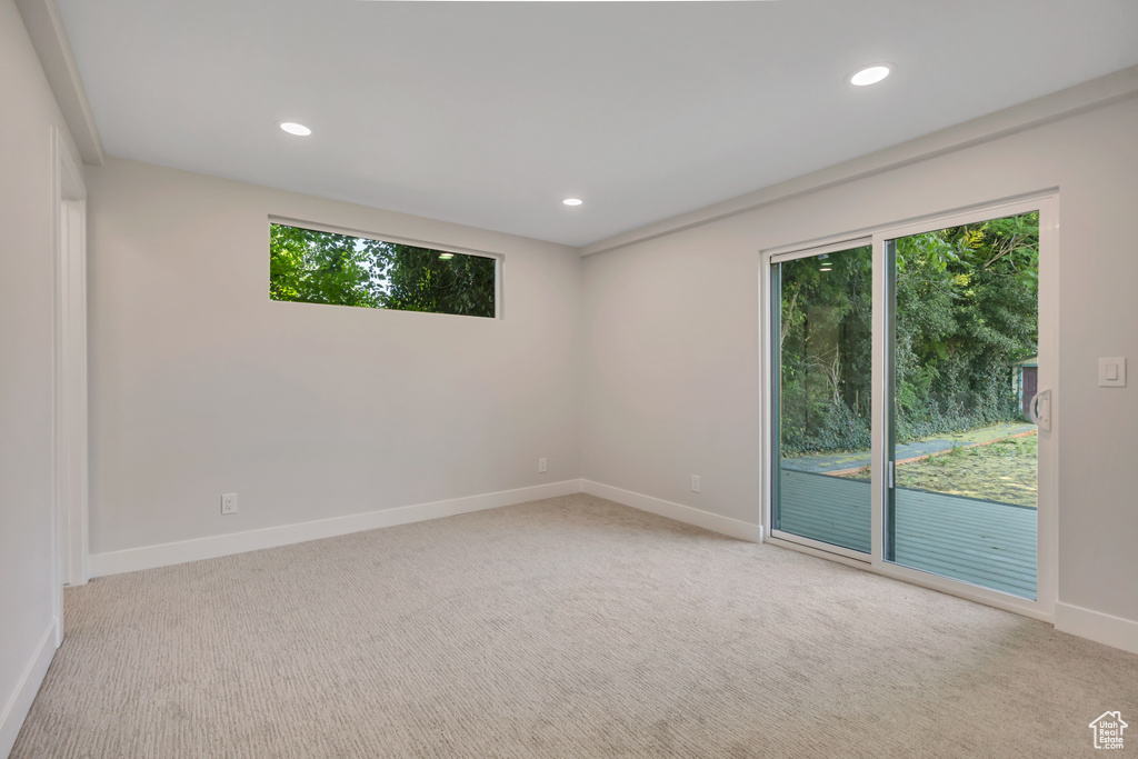 Carpeted empty room with recessed lighting and baseboards