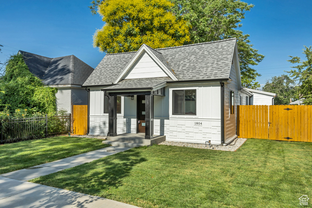 View of front of property featuring a gate, roof with shingles, and board and batten siding