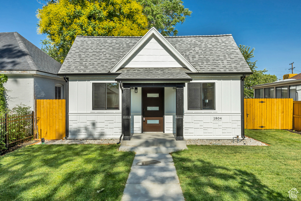 View of front of house with roof with shingles, board and batten siding, and a gate