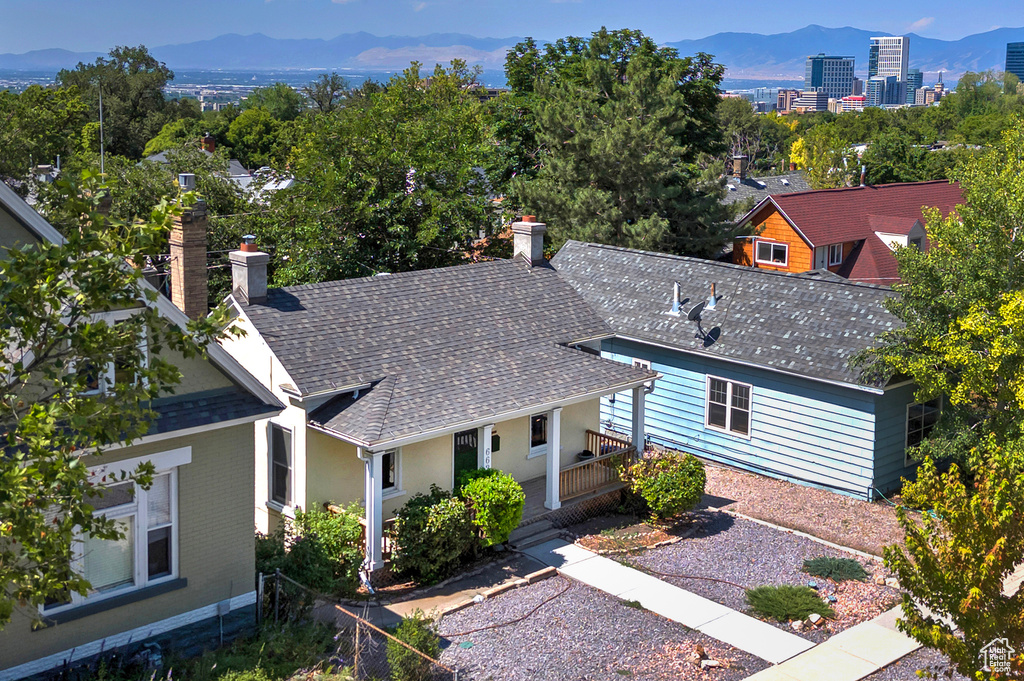 View of front of house with a mountain view, a shingled roof, and a chimney