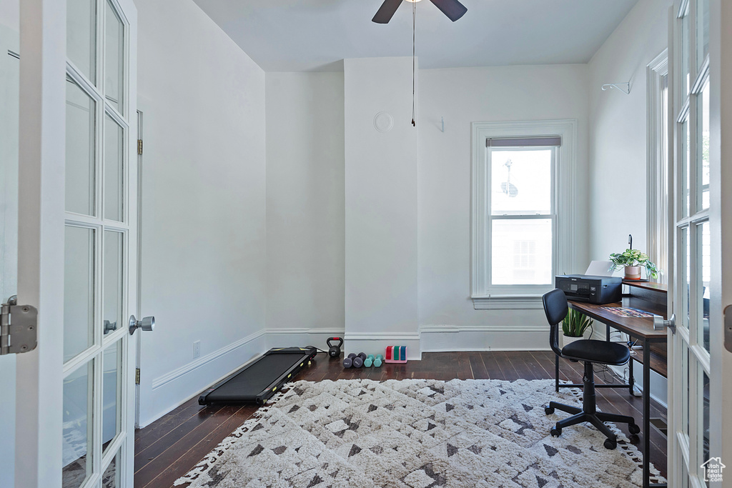 Office area with dark wood-style flooring, a ceiling fan, and french doors