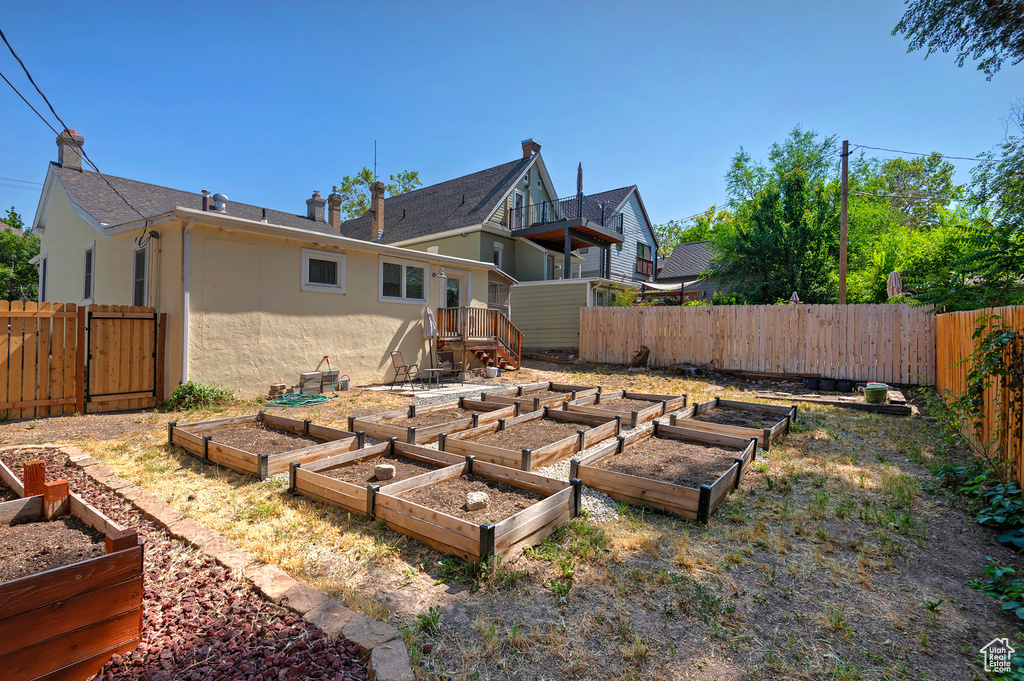 Back of property with stucco siding, a vegetable garden, and a fenced backyard