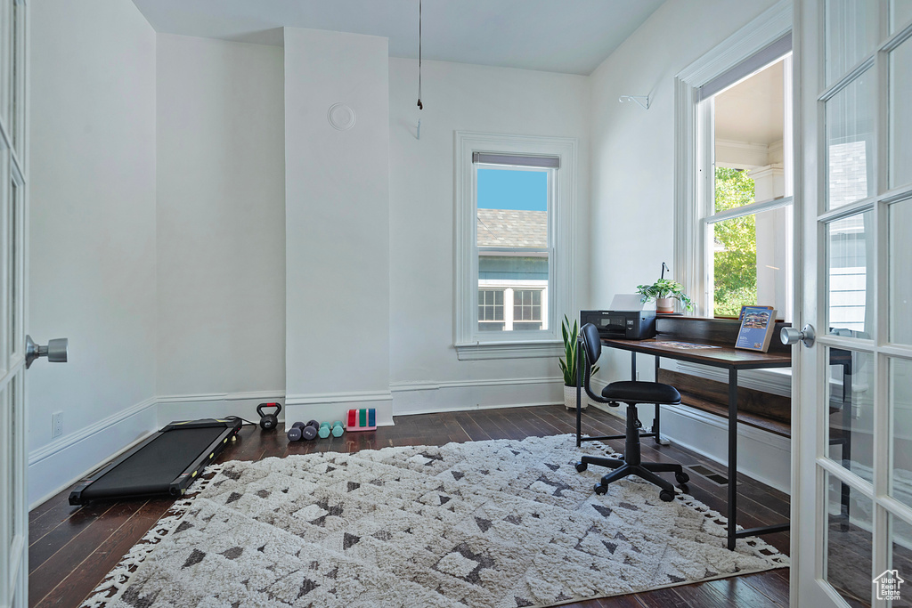 Office space featuring dark wood-type flooring and baseboards