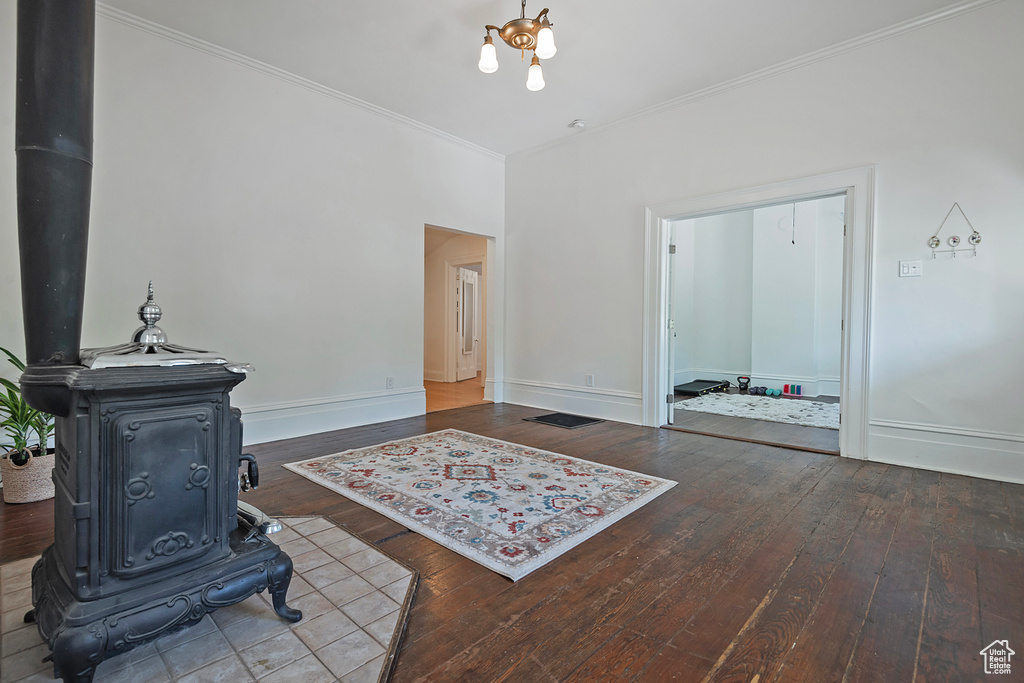 Living room with a wood stove, crown molding, and hardwood / wood-style flooring