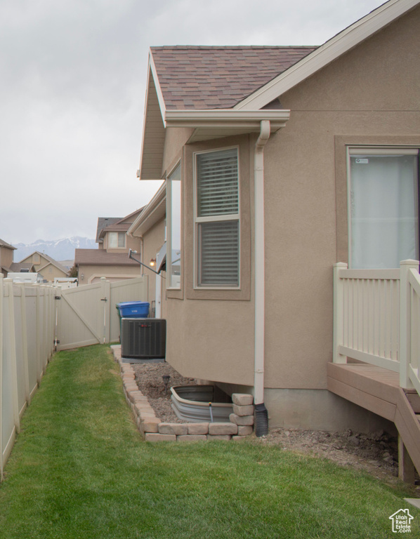 View of home\'s exterior with a gate, a shingled roof, a fenced backyard, and stucco siding