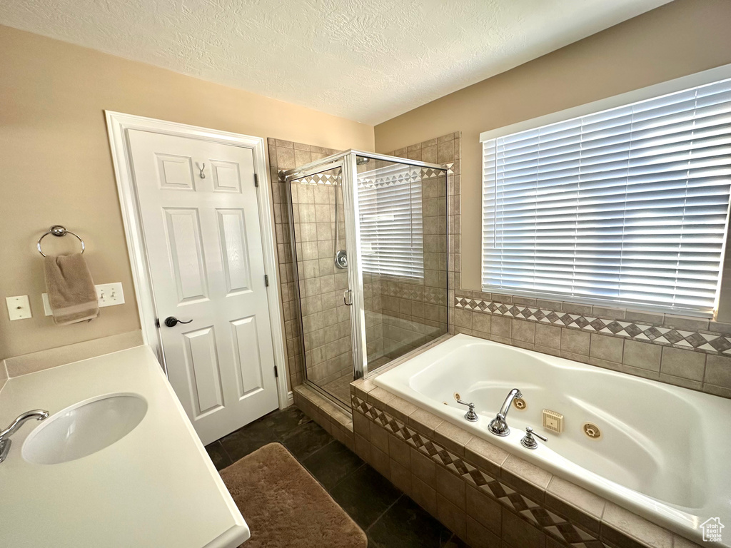 Full bath featuring a whirlpool tub, a shower stall, a textured ceiling, tile patterned flooring, and vanity