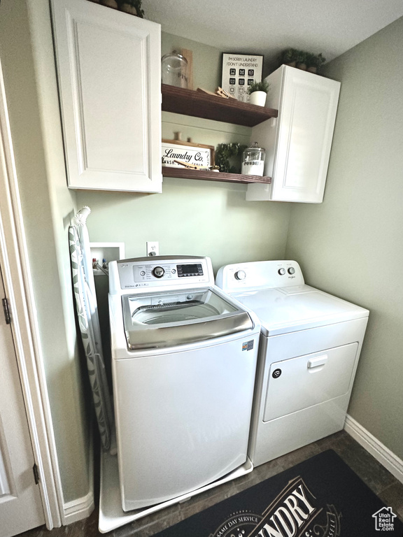 Washroom featuring washer and clothes dryer and cabinet space