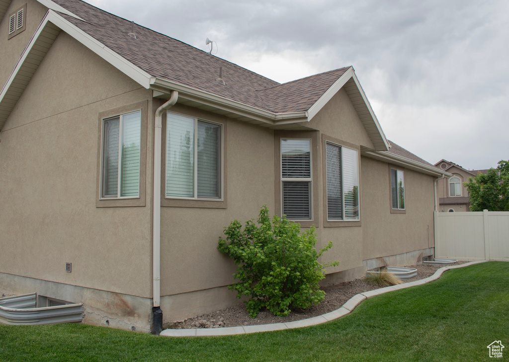 View of property exterior featuring a shingled roof and stucco siding