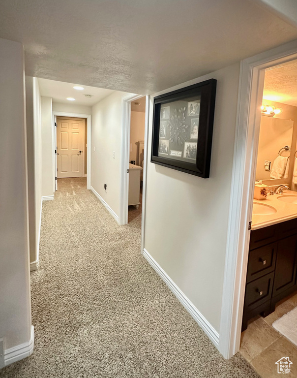 Hall featuring baseboards and light colored carpet
