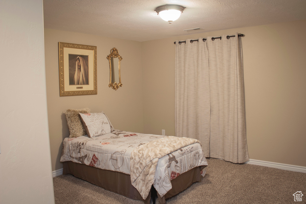 Bedroom featuring carpet flooring and a textured ceiling