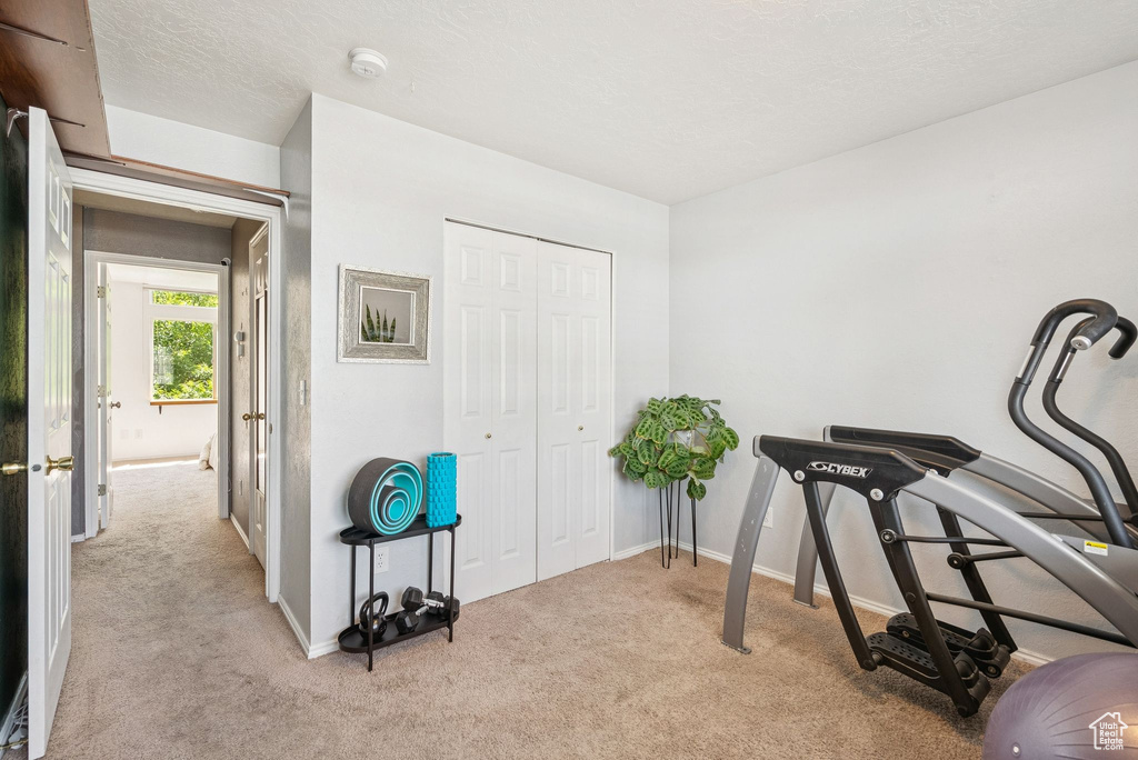 Exercise room with carpet flooring and baseboards