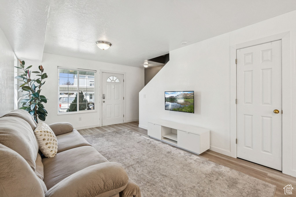 Living room featuring light wood-style flooring and baseboards
