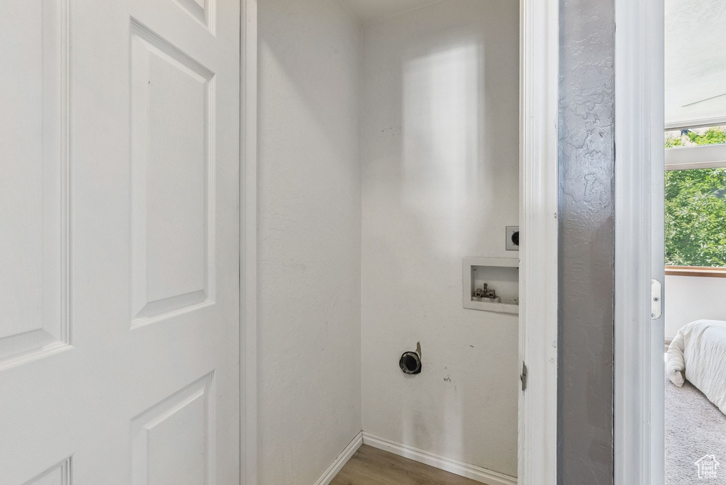 Laundry room featuring electric dryer hookup, washer hookup, and wood finished floors