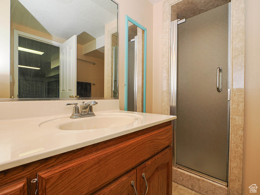 Full bath featuring vanity, a shower stall, and tile patterned floors
