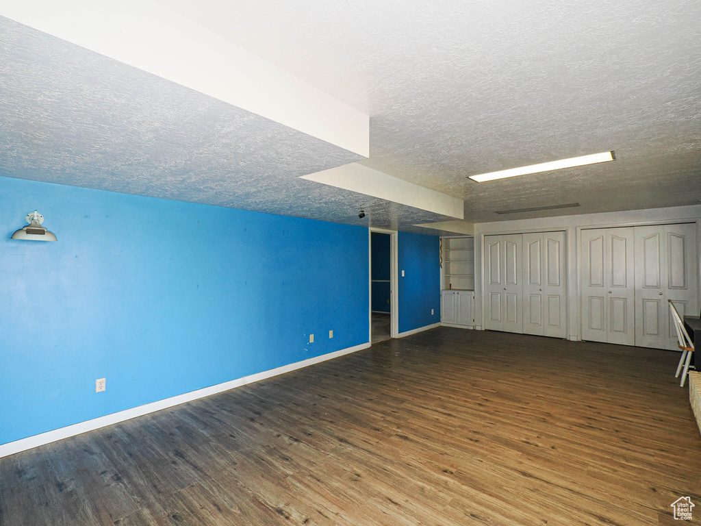 Additional living space with wood finished floors and a textured ceiling