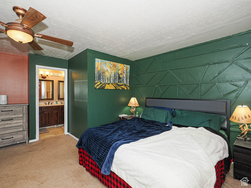 Bedroom with carpet flooring, a textured ceiling, a ceiling fan, and ensuite bathroom