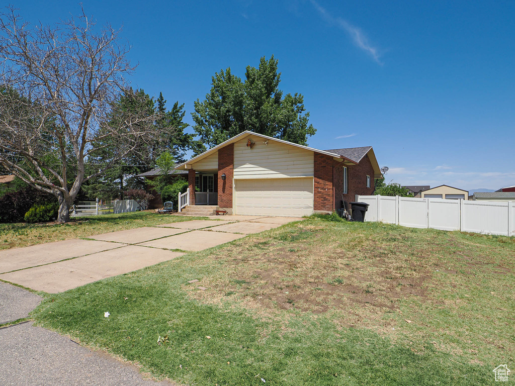 View of property exterior featuring brick siding, an attached garage, and concrete driveway